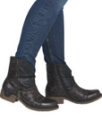 Woman in blue jeans wearing black leopard ankle boots with accent faux zipper.