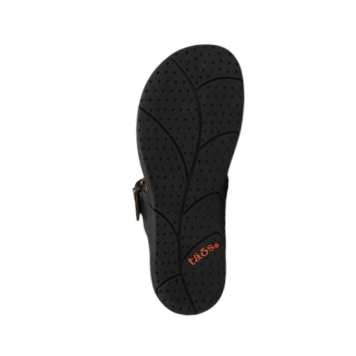 Black rubber outsole with leaf pattern tread and Taos logo near heel.