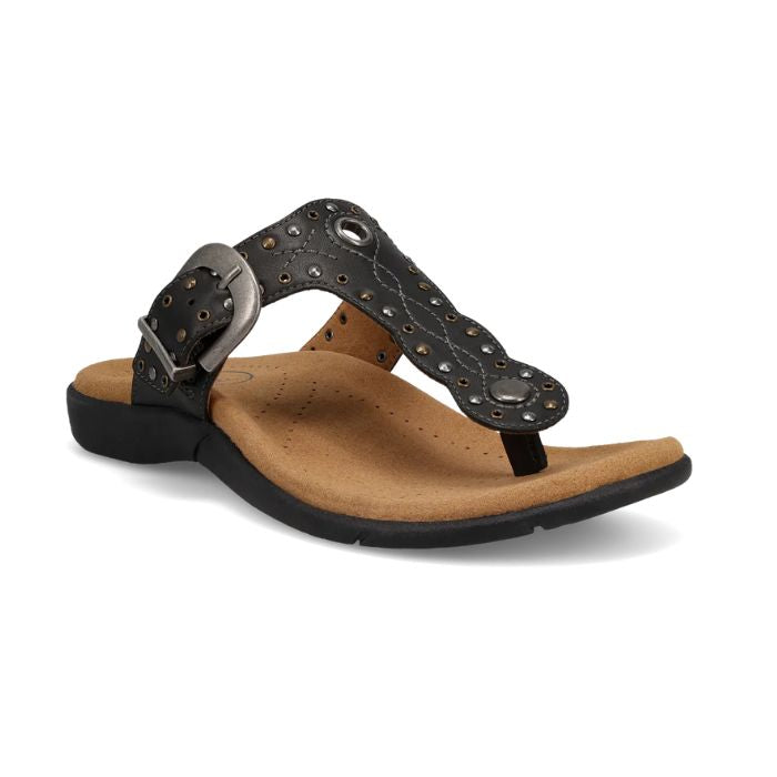 Black T-strap sandal with embroidery, rivets and grommet detailing and an antiqued adjustable buckle with beige footbed and black outsole.