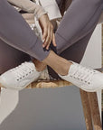 Lifestyle image of Winny Sneaker - Leather Lace-Up in white worn outdoors. Combines comfort and style for casual wear.