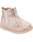 Pink kids ankle boot with rose gold leopard print pattern, elastic side goring and a tan soft bottom outsole.