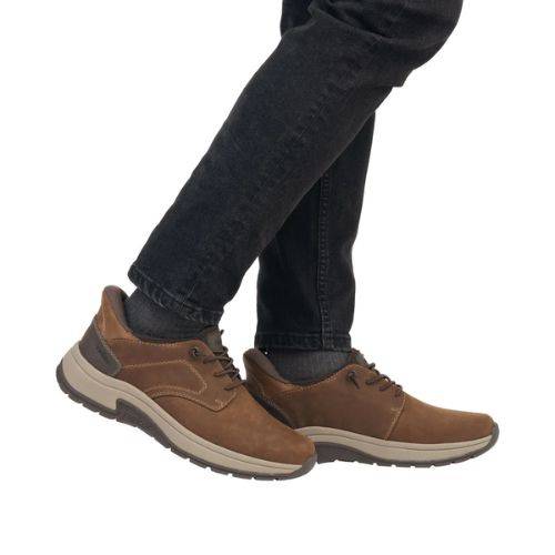 Brown leather slip on shoes worn with black jeans.