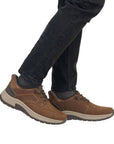 Brown leather slip on shoes worn with black jeans.