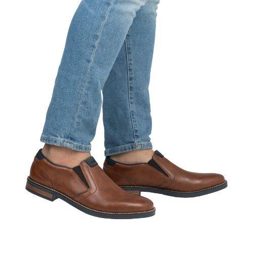 Model wearing brown leather loafers with jeans.