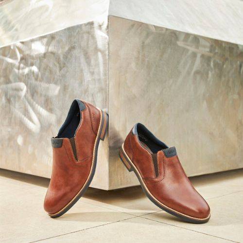 Pair of brown leather dress shoes displayed against a modern backdrop.