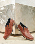 Pair of brown leather dress shoes displayed against a modern backdrop.