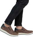 Model wearing Men's Rieker 16952 Slip-On Sneakers with black jeans, showcasing casual comfort and effortless slip-on design.