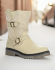 Beige Women's Bos & Co Anova Mid-Height Boot styled outdoors on snowy street, ideal for winter fashion and function.