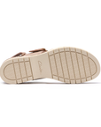 Beige light treaded outsole of wedge sandal with Clarks stamped in middle.