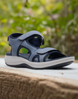 Women's Clarks Mira Bay Sport Sandal in blue displayed outdoors, highlighting its sporty style and breathable design for summer wear.