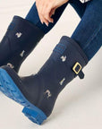 Model in jeans wearing the Molly Wellies in Navy. Grippy outsole is visible.