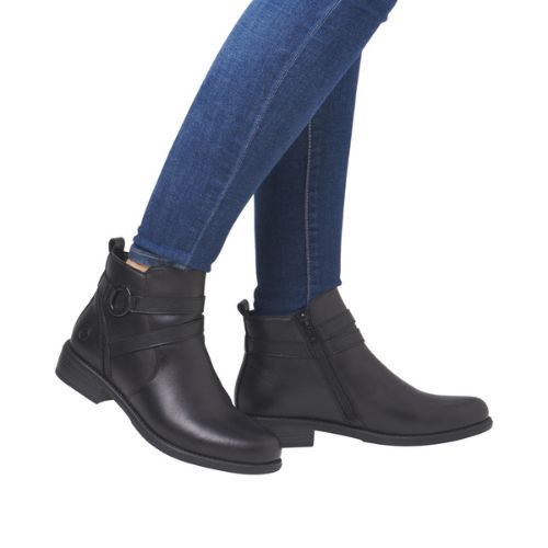 Model wearing black ankle boots styled with jeans.