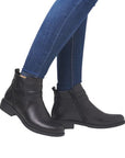 Model wearing black ankle boots styled with jeans.