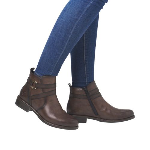 Model wearing brown ankle boots with blue jeans.