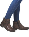 Model wearing brown ankle boots with blue jeans.