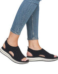 Model wearing black Remonte D1J55 sporty backstrap sandals with jeans, highlighting the casual and orthotic-friendly fit.