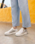 Outdoor scene with model in white Remonte D2E03 sneakers, showcasing breathable leather and casual fashion appeal.