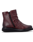 Deep burgundy ankle boot with side zippers, ruching and black treaded outsole.