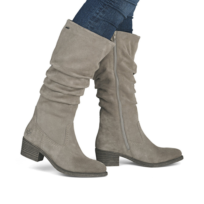 Grey knee-high boots worn with blue jeans