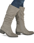 Grey knee-high boots worn with blue jeans