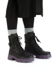 Black combat boot with black laces and purple platform outsole.