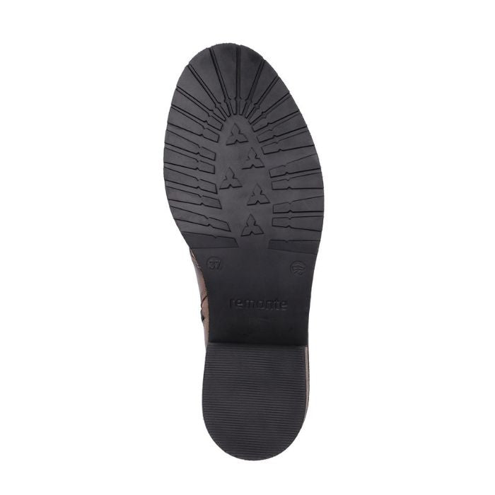 Black rubber outsole of women&#39;s boot with Remonte logo on center.