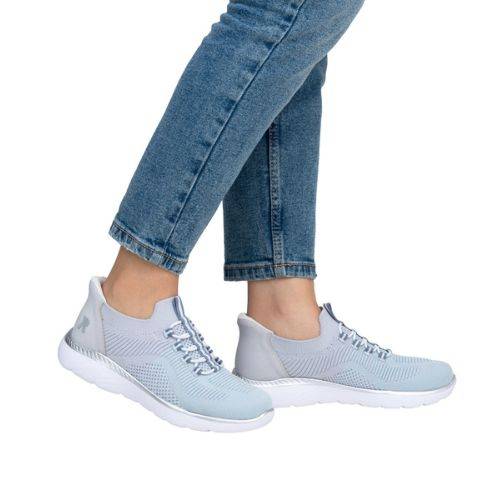 Model wearing Women's Rieker M5066 Slip-On Sneaker in light blue, paired with jeans for a relaxed and stylish outfit.