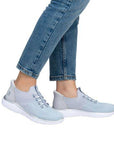 Model wearing Women's Rieker M5066 Slip-On Sneaker in light blue, paired with jeans for a relaxed and stylish outfit.