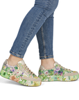 Floral sneakers worn with blue jeans.