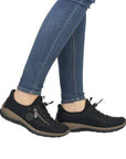 Model wearing black bungee lace Slip-On Sneakers with jeans.
