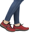 Model wearing red bungee lace Slip-On Sneakers with jeans.