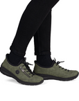 Green sneakers worn with black pants.