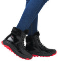 Model wearing Rieker W0063 women's waterproof winter boots with red soles and black patent finish, styled with jeans for casual winter wear.