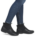 Black ankle boots worn with blue jeans.
