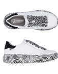 Pair of White platform sneakers with black and white laces, tan Rieker logo'd footbed, black heel counter and a black geometric line pattern on midsole.