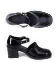 Pair of Black leather closed toe heel with a block heel, black Bueno logo'd outsole and silver buckle strap.