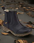 Black Women's El Naturalista Yggdrasil N158 Chelsea Boot displayed on autumn leaves background, highlighting its fall-ready style and comfort.
