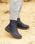 Black mid boots with front zipper worn in desert with grey khaki pants.