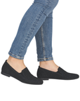 Black glittery loafers worn with blue jeans.