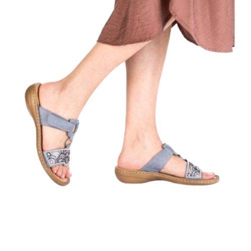 Model wearing blue Women's Rieker 608K2 Slide Sandals, showcasing their casual fit and stylish beaded upper for everyday wear.