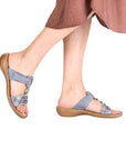 Model wearing blue Women's Rieker 608K2 Slide Sandals, showcasing their casual fit and stylish beaded upper for everyday wear.