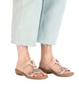 Model wearing beige Women's Rieker 608K2 Slide Sandals, perfect for casual outfits with a blend of comfort and elegance.
