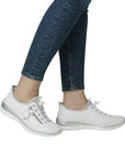 White Women's Rieker L32F1 Slip-On Sneakers styled with jeans, offering a sleek, comfortable fit for casual summer adventures.