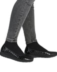 Black slip-on ballet flat worn with gray jeans.