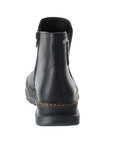 Heel view of black Chelsea boot with side zipper, tan stitching and a lugged outsole.