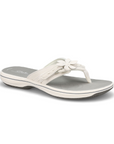 White thong sandal with white midsole, grey footbed with white designs including Clarks Cloudsteppers logo, fabric toe post, and adjustable white strap with white flower. Dark grey outsole with rocker bottom design.