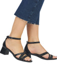 Model wearing black Remonte D1L51 sling-back heels with ankle strap and block heel, perfect for casual or dressy outfits.