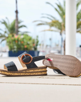 Pair of sandals on a cement pathway with a blurred outdoor background.