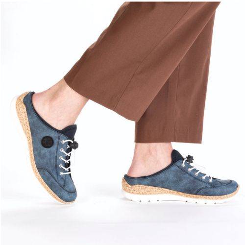 Model wearing the Rieker N4210 women's clog with brown pants, highlighting the casual slip-on style and cushioned comfort for daily wear.