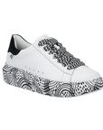 White platform sneaker with black and white laces, black heel counter and a black geometric line pattern on midsole.
